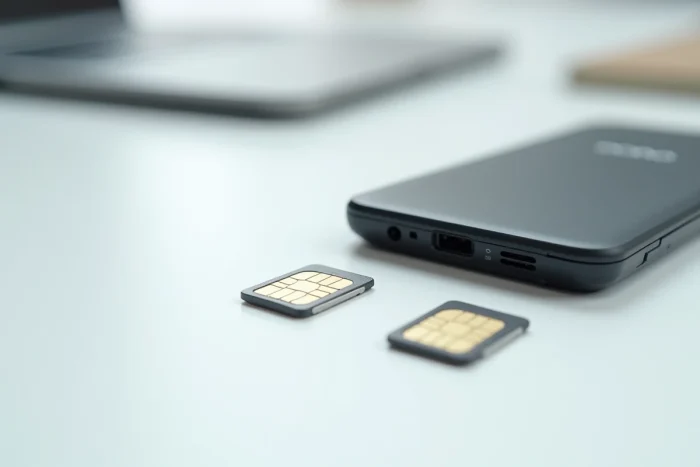 Gros plan sur un téléphone Doro 2404 ouvert avec différentes tailles de cartes SIM disposées sur un bureau blanc